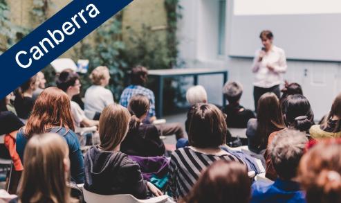 Female speaker giving presentation in lecture hall